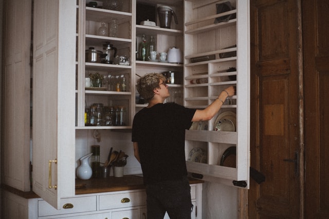 A person looking into a pantry cupboard