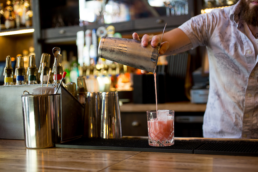 A man pouring a blackberry drink on Christmas Eve at the Lionfish in San Diego