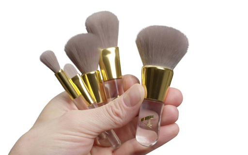 A hand holding Veil 5 piece cosmetic brush set.