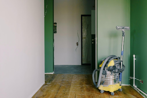 A hall way with a cracked door in serious need for home improvements.