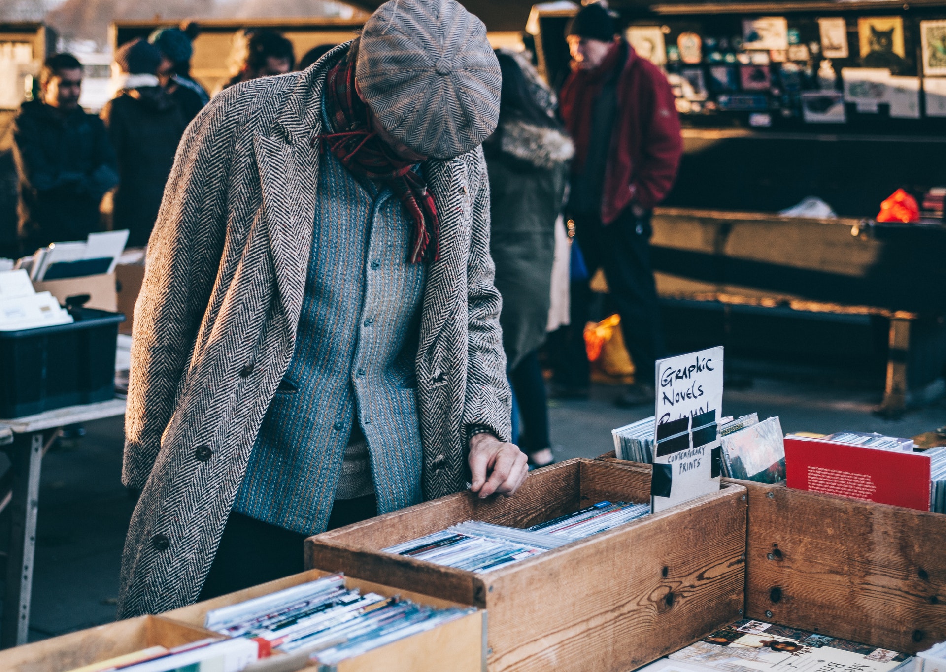 A man browsing through different items at a garage sale.