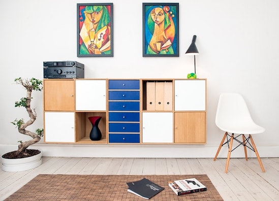 A room decorated with Wooden board in brown, white, and blue color with interesting artwork above it showing How to Use Colors in Your Home Design