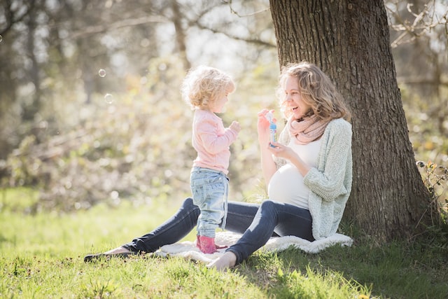 mother and daughter sitting by a tree on mother's day.