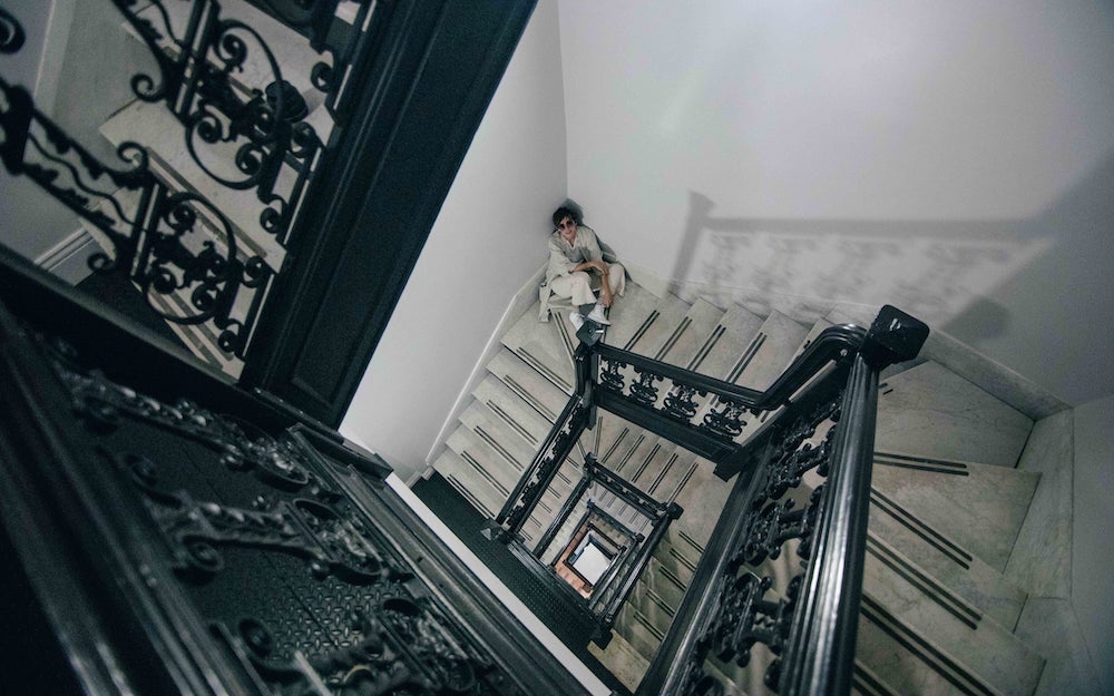 A lady taking a break on some stairs while moving.