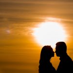 a couple on Valentine's Day with a sunset behind them