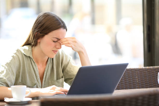 A woman holding her hand to her head from too much scree time