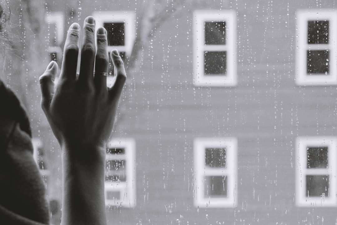 Lonely isolated person looking out window