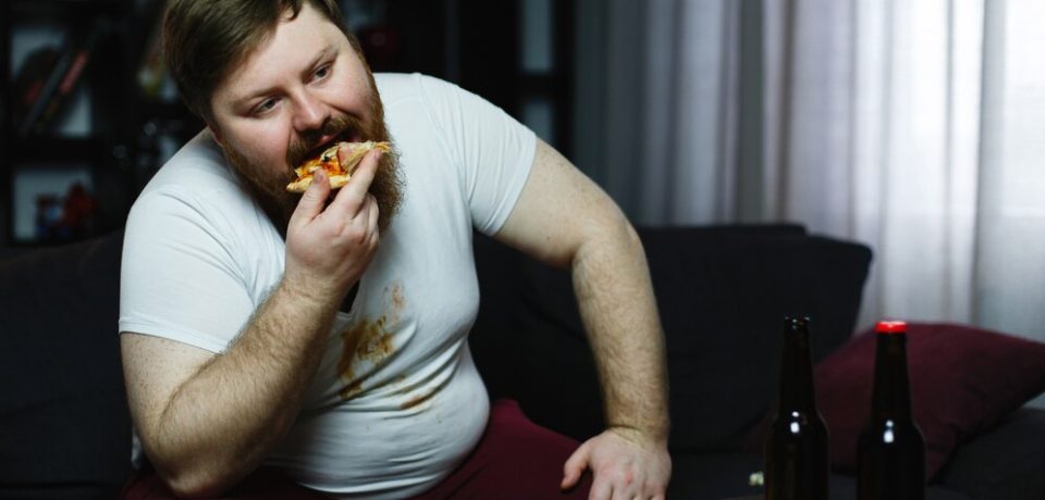 ugly-fat-man-eats-pizza-sitting-sofa_8353-5503